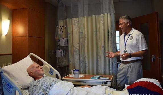 Photo of Lake Health Volunteer Jay visiting with hospitalized veteran